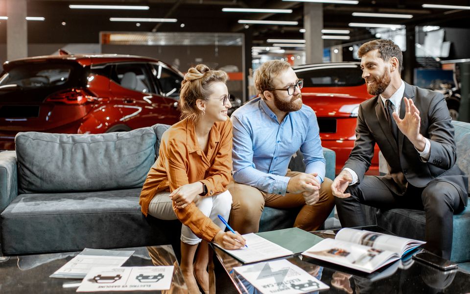 A salesperson with two customers in the showroom lounge